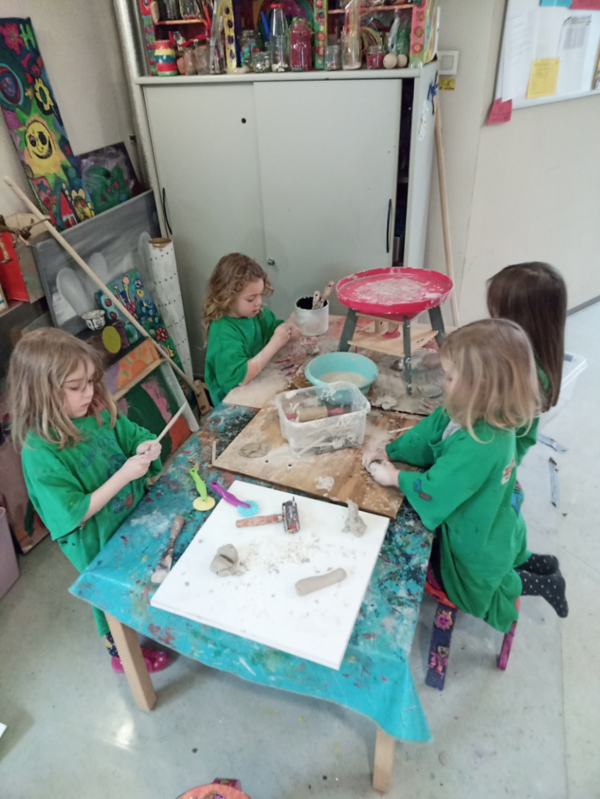 Kindergartenkinder sitzen eifrig an einem Tisch und arbeiten mit Ton.