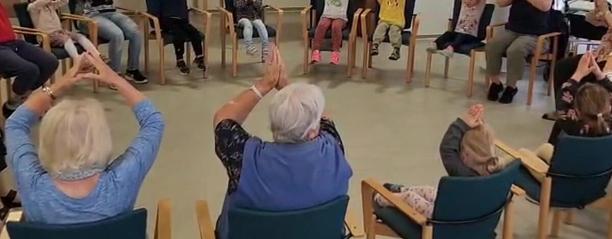 Stuhlkreis mit Senioren, Seniorinnen und Kindergartenkinder