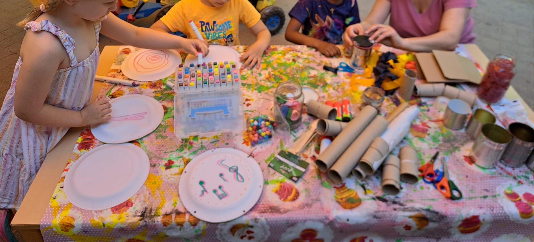 Foto zeigt Kinderhände die fleißig Musikinstrumente basteln