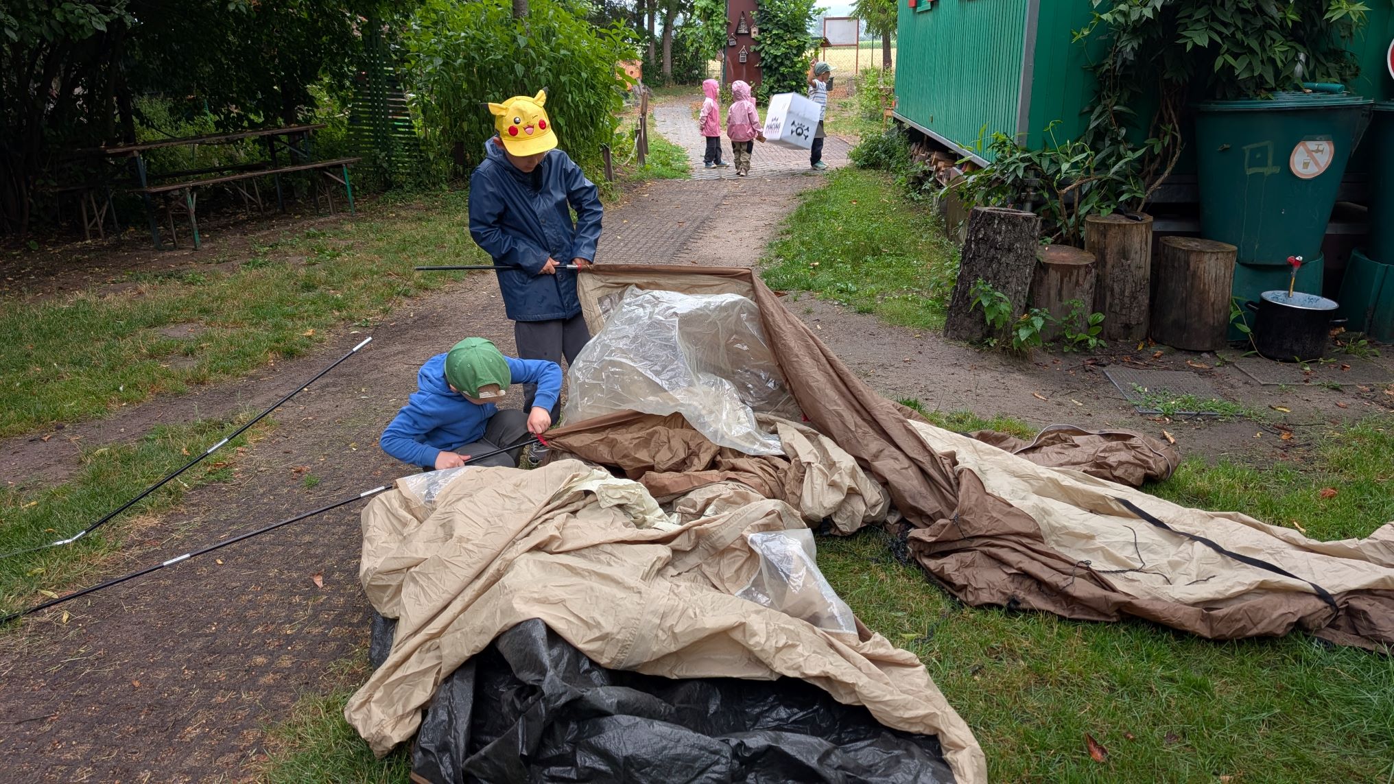 Waldkindergartenkinder bauen gemeinsam ihr Zelt auf.